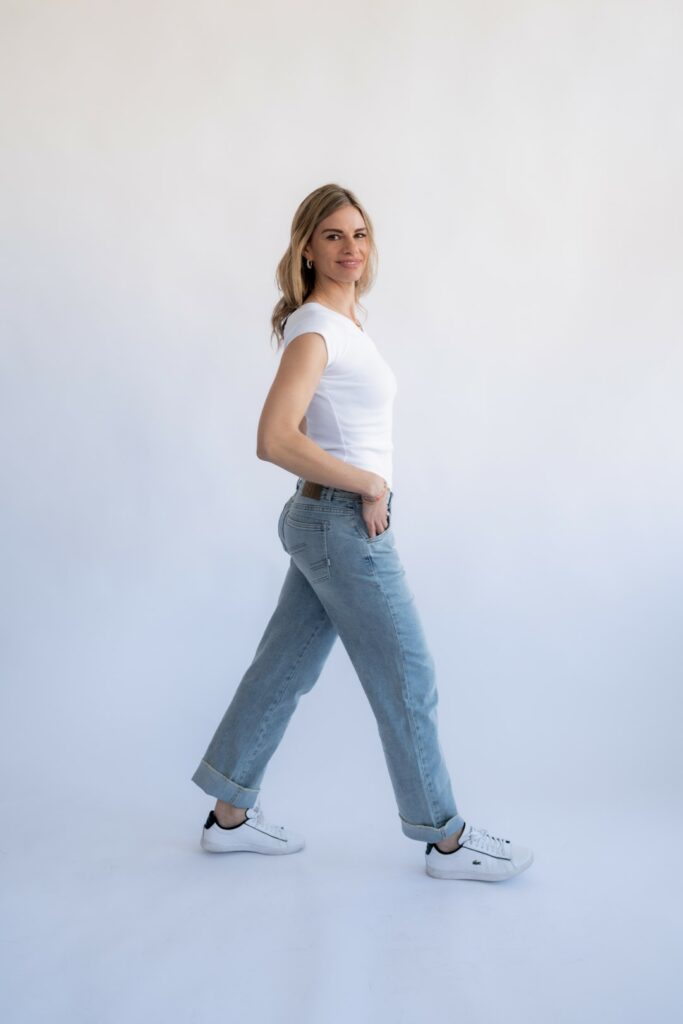 Debora geht in Jeans und weissem Shirt durchs Studio